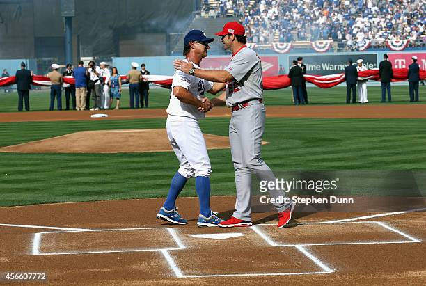 Manager Don Mattingly of the Los Angeles Dodgers greets manager Mike Matheny outfield the St. Louis Cardinals at home plate before Game One of the...