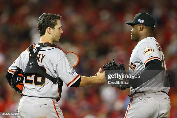 Buster Posey and Santiago Casilla of the San Francisco Giants celebrate their 3 to 2 win over the Washington Nationals during Game One of the...