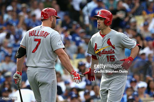 Randal Grichuk of the St. Louis Cardinals celebrates with teammate Matt Holliday after hitting a homerun to score in the first inning of Game One of...