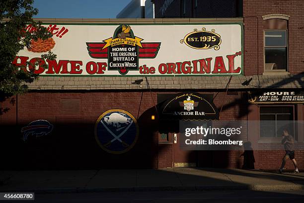 Pedestrian walks past the Anchor Bar in Buffalo, New York, U.S., on Wednesday, Sept. 24, 2014. The Federal Reserve Bank of New York's empire state...