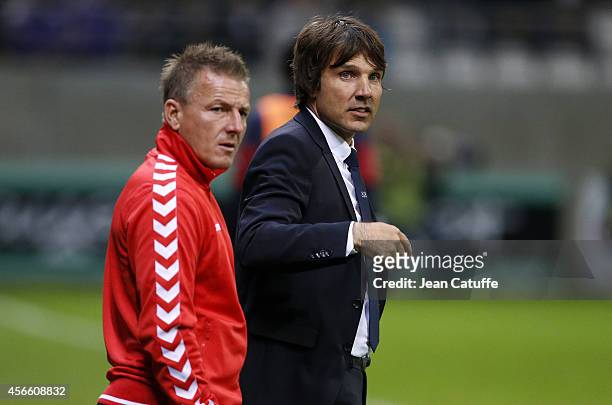 Head coach of Stade de Reims Jean-Luc Vasseur and his assistant-coach Olivier Guegan look on during the French Ligue 1 match between Stade de Reims...