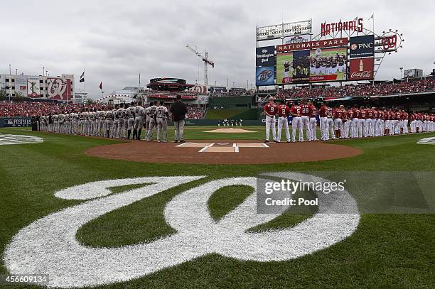 The San Francisco Giants and the Washington Nationals line up during pre game ceremonies for Game One of the National League Division Series at...