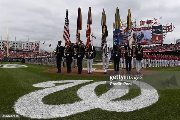 The San Francisco Giants and the Washington Nationals line up during pre game ceremonies for Game One of the National League Division Series at...