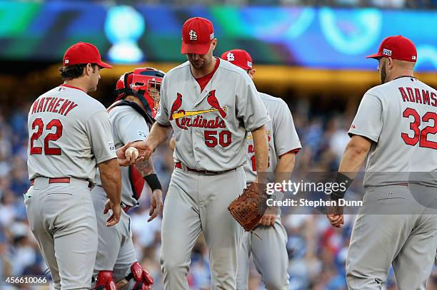 Starting pitcher Adam Wainwright of the St. Louis Cardinals gives the ball to manager Mike Matheny as he leaves the game in the fifth inning of Game...