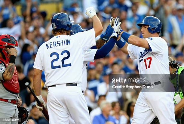 Clayton Kershaw and Carl Crawford of the Los Angeles Dodgers celebrate as A.J. Ellis crosses home plate after his two-run homerun in the fifth inning...