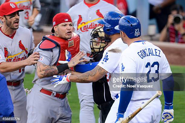 Adrian Gonzalez of the Los Angeles Dodgers exchanges words with the St. Louis Cardinal Yadier Molina in the third inning of Game One of the National...