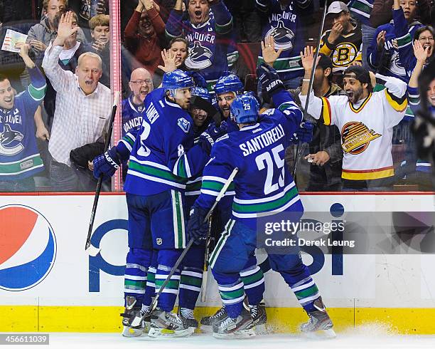 Chris Tanev, Dan Hamhuis, and Chris Higgins and Mike Santorelli of the Vancouver Canucks celebrate after Chris Higgins scored the team's third goal...