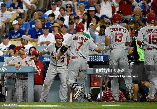 Matt Holliday of the St. Louis Cardinals celebrates his three run homerun with teammates in the seventh inning during Game One of the National League...