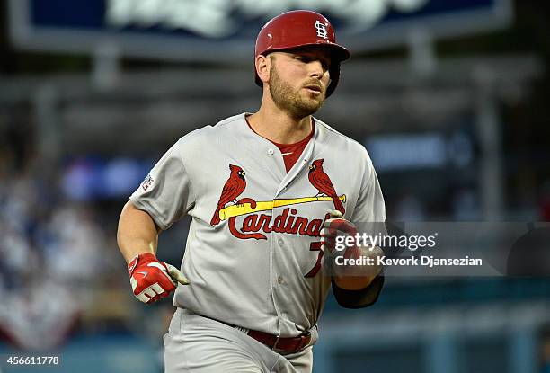 Matt Holliday of the St. Louis Cardinals rounds the bases after his three run homerun with teammates in the seventh inning during Game One of the...