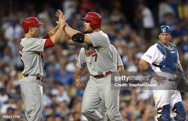 Matt Holliday of the St. Louis Cardinals celebrates his three run homerun with teammates in the seventh inning during Game One of the National League...