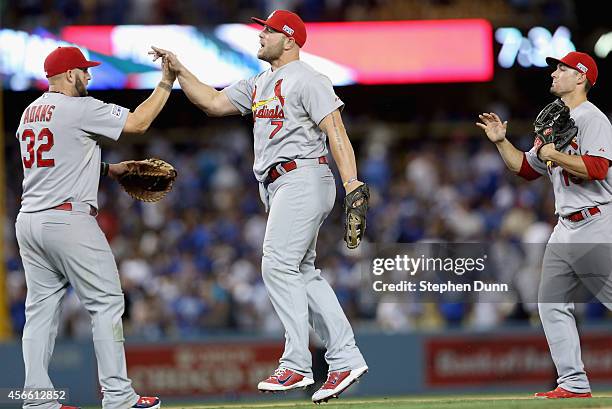 Matt Holliday and Matt Adams of the St. Louis Cardinals celebrate their 10-9 win over the Los Angeles Dodgers in Game One of the National League...