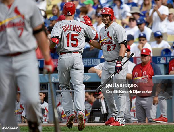 Randal Grichuk of the St. Louis Cardinals celebrates with teammate Jhonny Peralta after hitting a homerun to score in the first inning of Game One of...