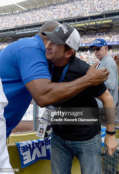 Owner Peter Guber of the Los Angeles Dodgers greets Magic Johnson before Game One of the National League Division Series against the St. Louis...