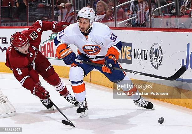 Frans Nielsen of the New York Islanders looks to pass the puck defended by Keith Yandle of the Phoenix Coyotes during the NHL game at Jobing.com...