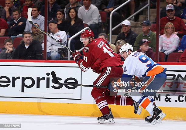 Martin Hanzal of the Phoenix Coyotes skates ahead of John Tavares of the New York Islanders during the NHL game at Jobing.com Arena on December 12,...