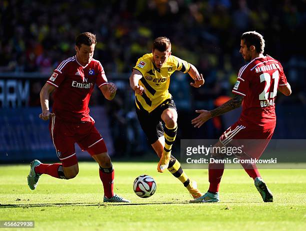 Marcell Jansen and Valon Behrami of Hamburger SV challenge Erik Durm of Borussia Dortmund during the Bundesliga match between Borussia Dortmund and...