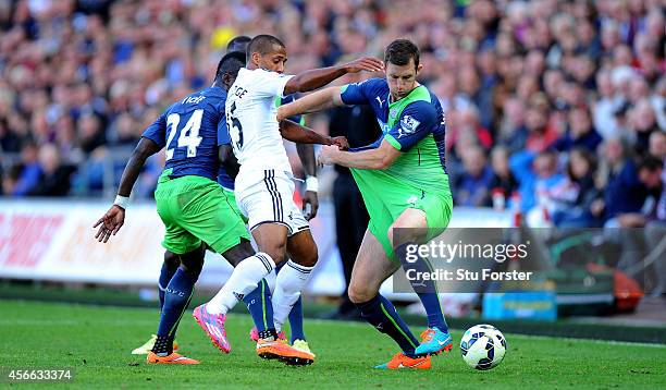 Newcastle player Mike Williamson is tugged by Swansea player Wayne Routledge during the Barclays Premier League match between Swansea City and...