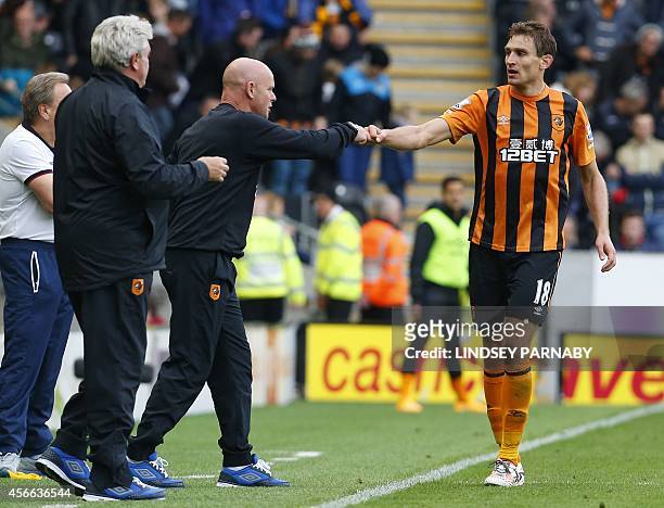 Hull City's Croatian striker Nikica Jelavic celebrates scoring their second goal with assistant manager Steve Agnew during the English Premier League...