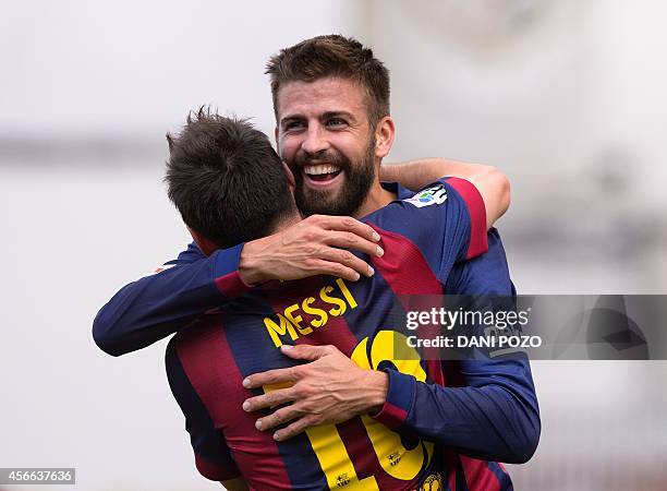 Barcelona's Argentinian forward Lionel Messi celebrates with teammate Barcelona's defender Gerard Pique after scoring during the Spanish league...