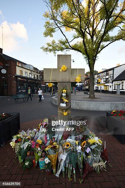 Floral tributes adorn the Eccles Cross for murdered aid worker Alan Henning in Eccles, north west England on October 4, 2014. Britain reacted with...