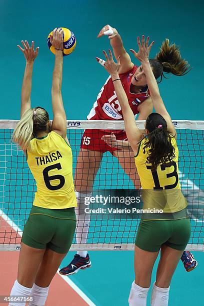 Tatiana Kosheleva of Russia spikes as De Paula Castro and Thaisa Menezes of Brazil block during the FIVB Women's World Championship pool F match...