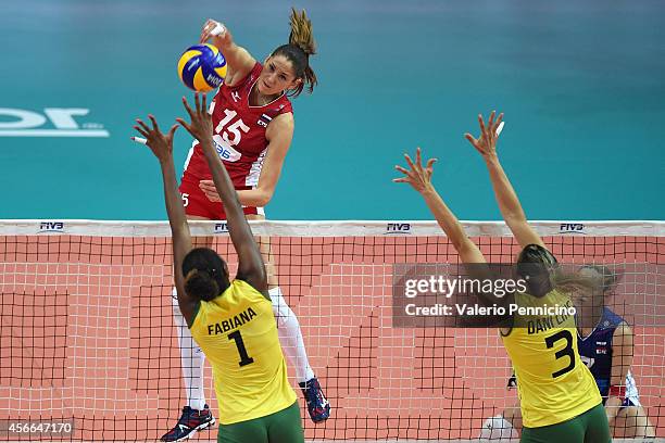 Tatiana Kosheleva of Russia spikes as Lins Danielle and Fabiana Claudino of Brazil block during the FIVB Women's World Championship pool F match...