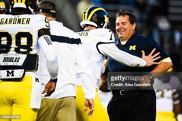 Head coach Brady Hoke of the Michigan Wolverines jokes with Shane Morris before a game against the Rutgers Scarlet Knights at High Point Solutions...