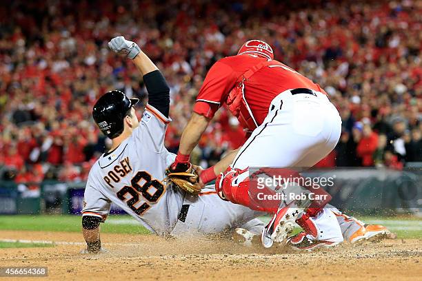 Wilson Ramos of the Washington Nationals tags out Buster Posey of the San Francisco Giants at home plate after Pablo Sandoval of the San Francisco...