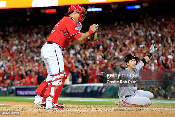 Wilson Ramos of the Washington Nationals tags out Buster Posey of the San Francisco Giants at home plate after Pablo Sandoval of the San Francisco...