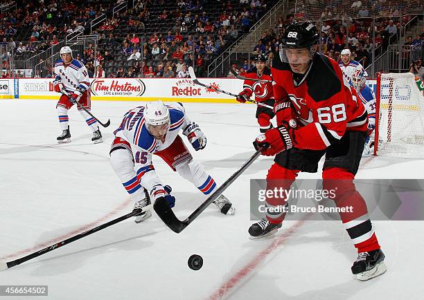 Jaromir Jagr of the New Jersey Devils moves the puck against Matthew Lombardi of the New York Rangers during the second period at the Prudential...