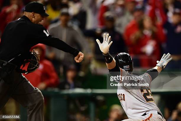 Buster Posey of the San Francisco Giants argues for a call of safe after being tagged out at home plate by Wilson Ramos of the Washington Nationals...