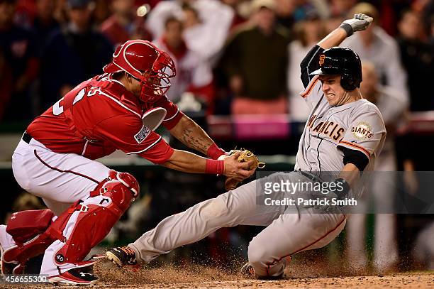 Wilson Ramos of the Washington Nationals tags out Buster Posey of the San Francisco Giants at home plate after Pablo Sandoval of the San Francisco...