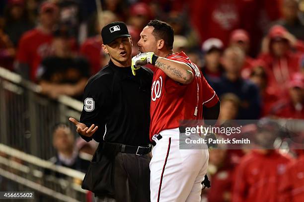 Asdrubal Cabrera of the Washington Nationals argues with a stike call with home plate umpire Vic Carapazza in the tenth inning against Jeremy Affeldt...
