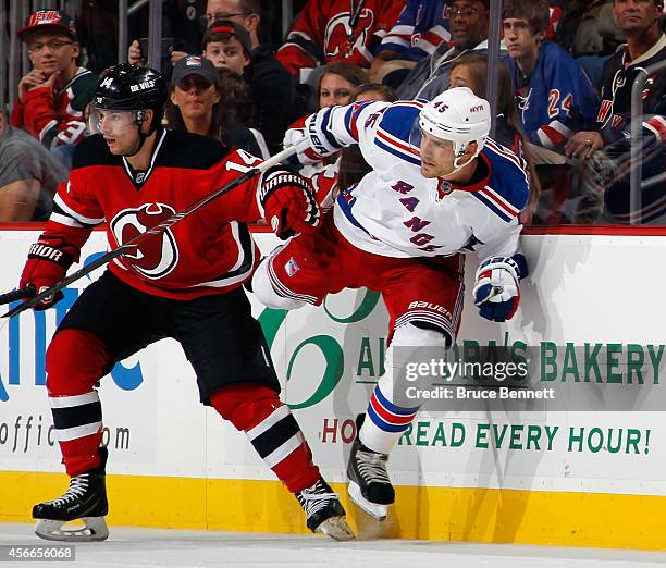 Matthew Lombardi of the New York Rangers squeezes past Adam Henrique of the New Jersey Devils during the third period at the Prudential Center on...
