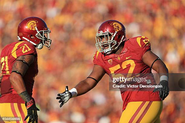 Defensive tackle Delvon Simmons of the USC Trojans celebrates after a defensive play with teammate safety Su'a Cravens in the first quarter of their...