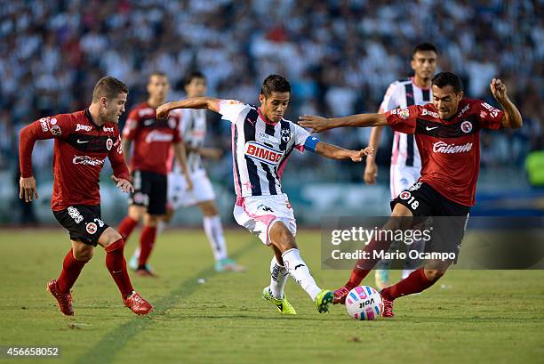 Severo Meza of Monterrey fights for the ball with Greg Garza and Juan Arango of Tijuana during a match between Monterrey and Tijuana as part of 12th...