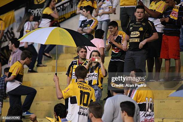 Supporters of Criciuma cheer their team during the match between Criciuma and Atletico MG for the Brazilian Series A 2014 at Heriberto Hulse Stadium...