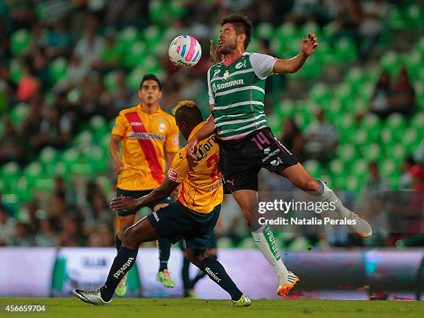 Nestor Araujo of Santos and Duvier Riascos of Morelia fight for the ball during a match between Santos Laguna and Morelia as part of 12th round...