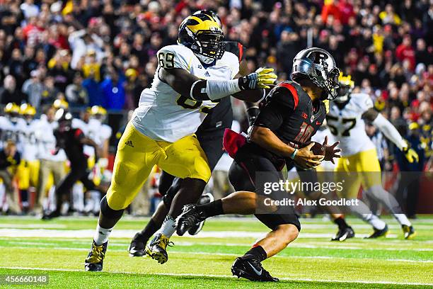 Gary Nova of the Rutgers Scarlet Knights is sacked by Willie Henry of the Michigan Wolverines in the third quarter at High Point Solutions Stadium on...