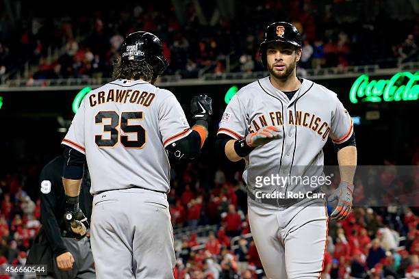 Brandon Belt of the San Francisco Giants celebrates with his teammate Brandon Crawford after hitting a solo home run to right field in the eighteenth...