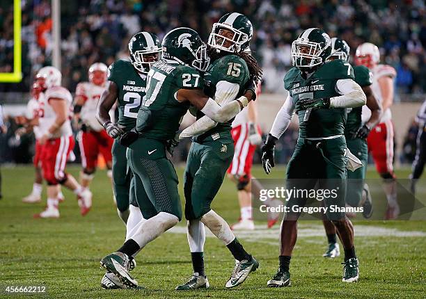 Trae Waynes of the Michigan State Spartans celebrates a fourth quarter interception to seal a 27-22 win over the Nebraska Cornhuskers with teammates...