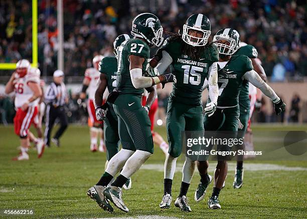 Trae Waynes of the Michigan State Spartans celebrates a fourth quarter interception to seal a 27-22 win over the Nebraska Cornhuskers with teammates...