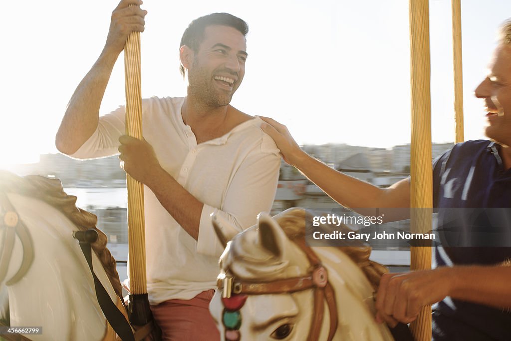 Two gay men laughing on merry -go- round