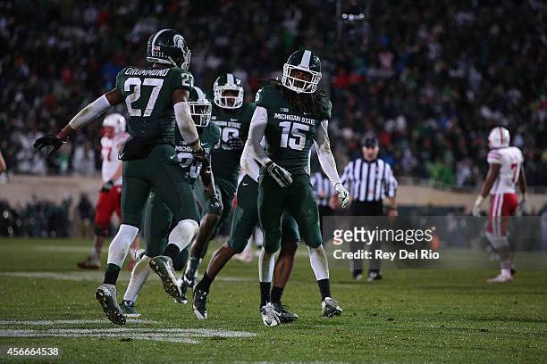 Trae Waynes of the Michigan State Spartans celebrates a fourth quarter interception againstbNebraska Cornhuskers with teammates Kurtis Drummond and...