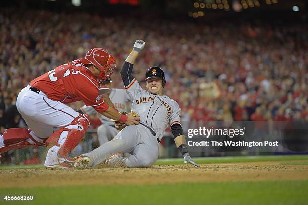 San Francisco catcher Buster Posey comes into home but was tagged out by Washington catcher Wilson Ramos in the top of the ninth inning as the...