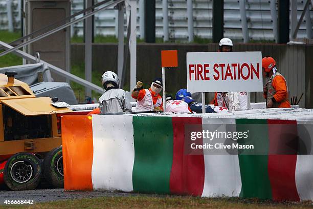 Jules Bianchi of France and Marussia receives urgent medical treatment after crashing during the Japanese Formula One Grand Prix at Suzuka Circuit on...