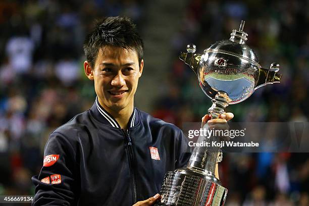 Winner Kei Nishikori of Japan celebrates with his trophy after winning the men's singles final match against Milos Raonic of Canada on day seven of...