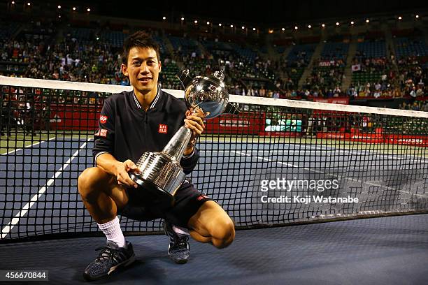 Winner Kei Nishikori of Japan celebrates with his trophy after winning the men's singles final match against Milos Raonic of Canada on day seven of...
