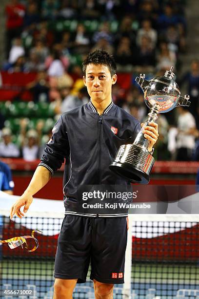 Winner Kei Nishikori of Japan celebrates with his trophy after winning the men's singles final match against Milos Raonic of Canada on day seven of...