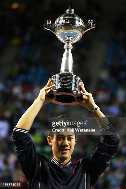 Winner Kei Nishikori of Japan celebrates with his trophy after winning the men's singles final match against Milos Raonic of Canada on day seven of...